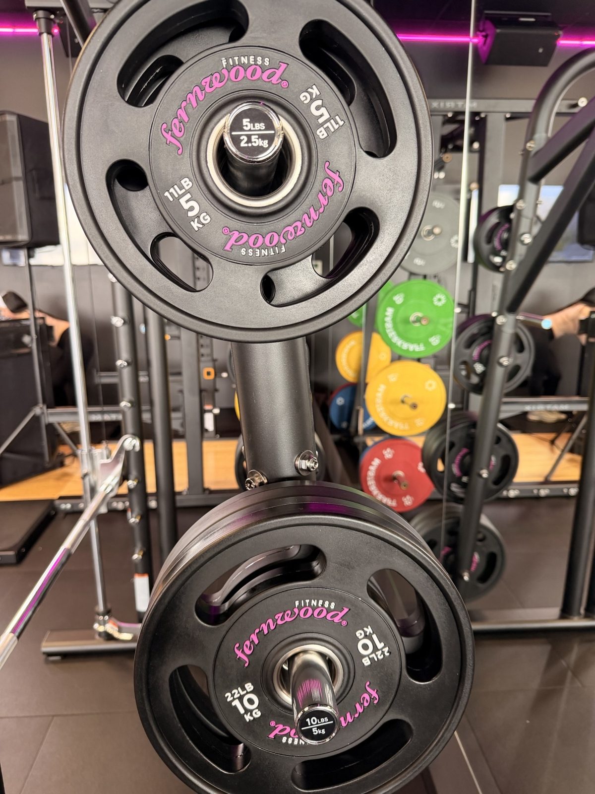 Fernwood-branded 5 kg and 10 kg 4-grip urethane Olympic plates in magenta script